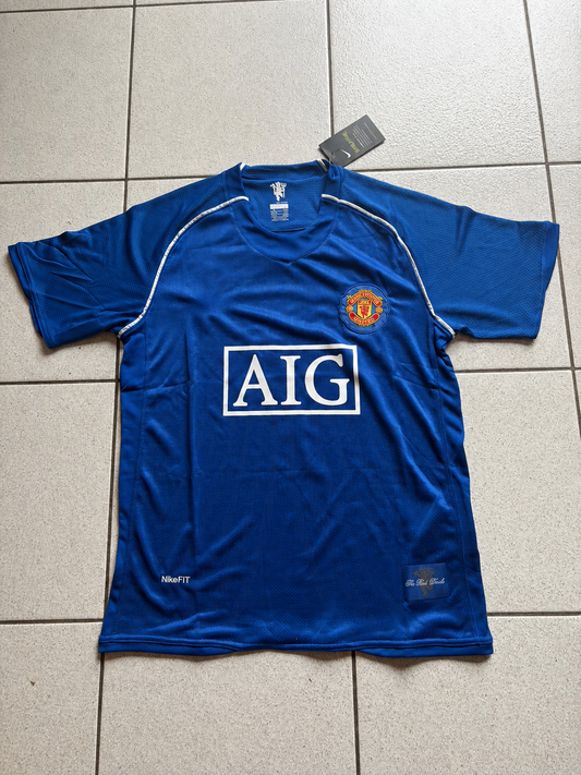 Maillot rétro Manchester United 2008 bleu, sponsor AIG et liserés blancs, vue de face